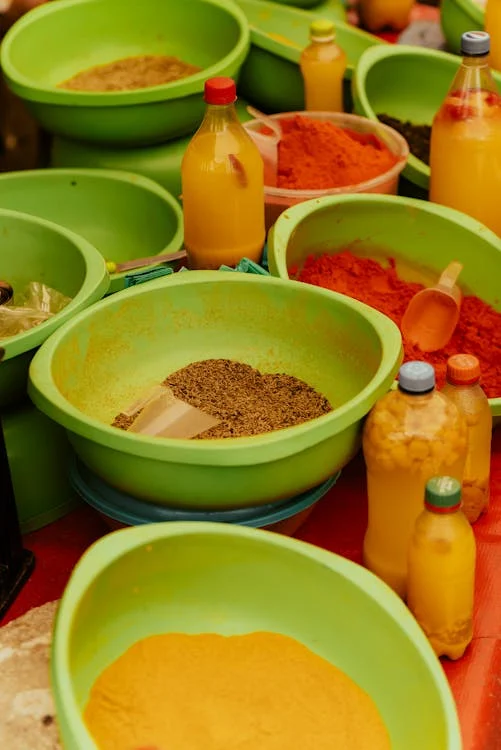 fresh display of herbs and spices alongside traditional utensils used to prepare masalas.