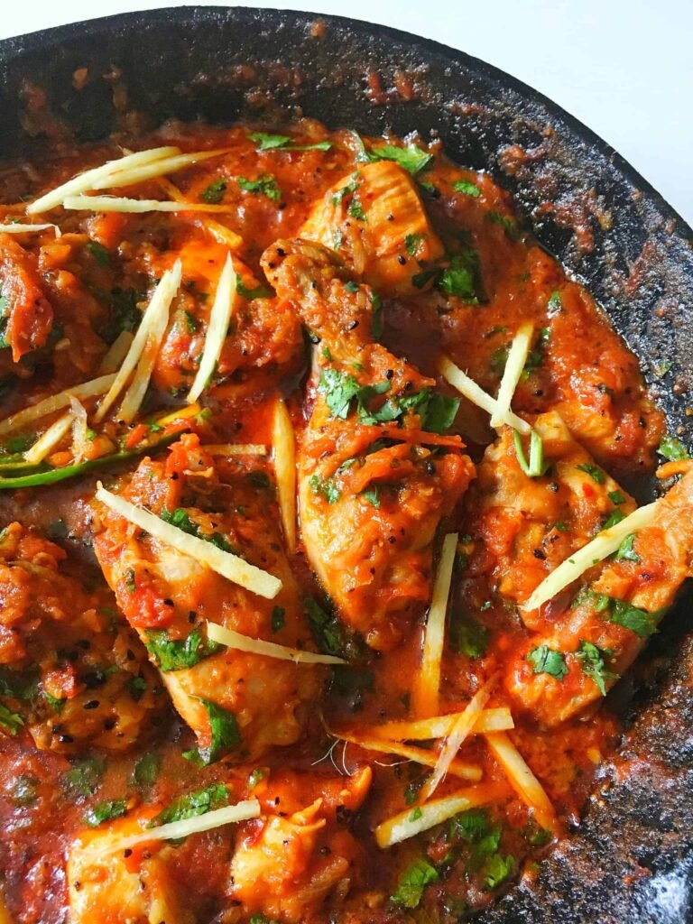 A beautifully served plate of Chicken Karahi with naan and garnished with fresh coriander.